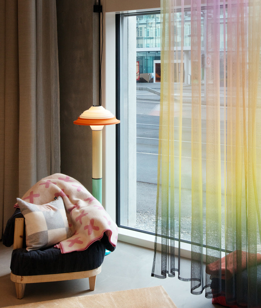 Colourful cushions viewed through a translucent curtain